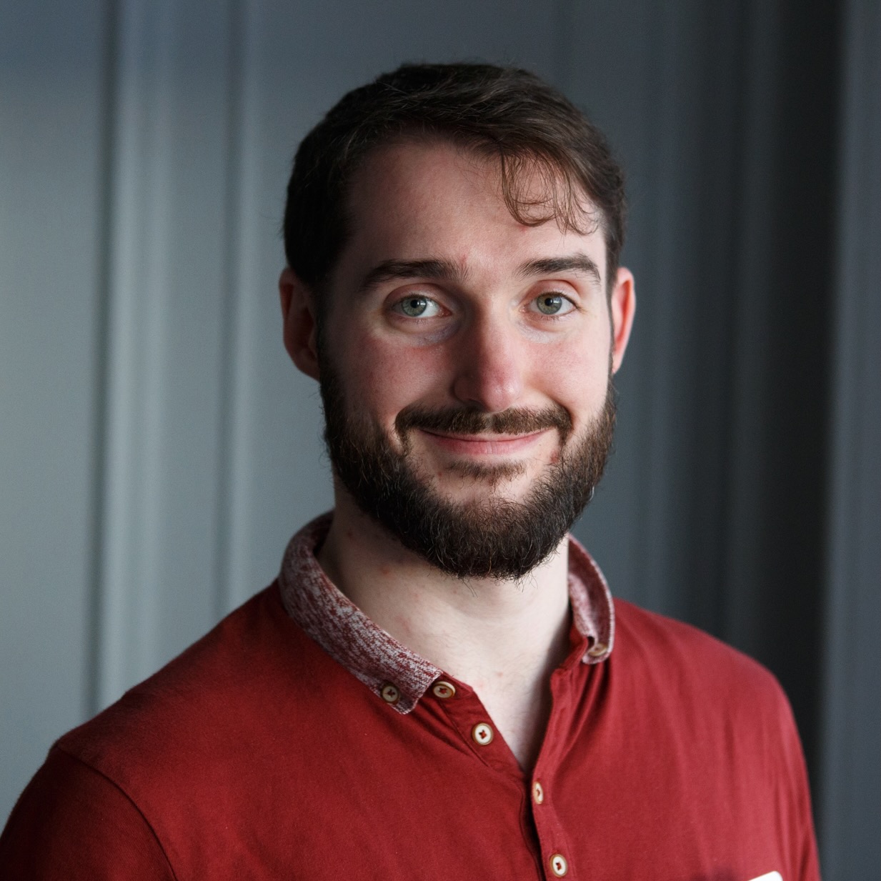 Smiling man with a beard and dark short hair